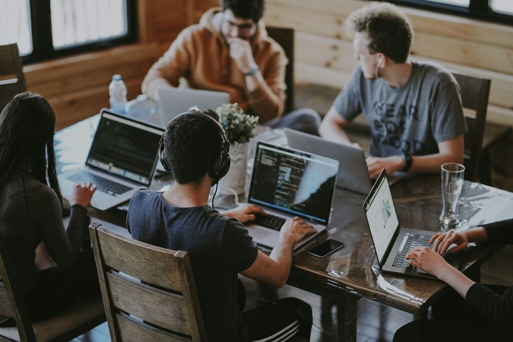 Team arbeitet gemeinsam an Laptops im modernen Büro